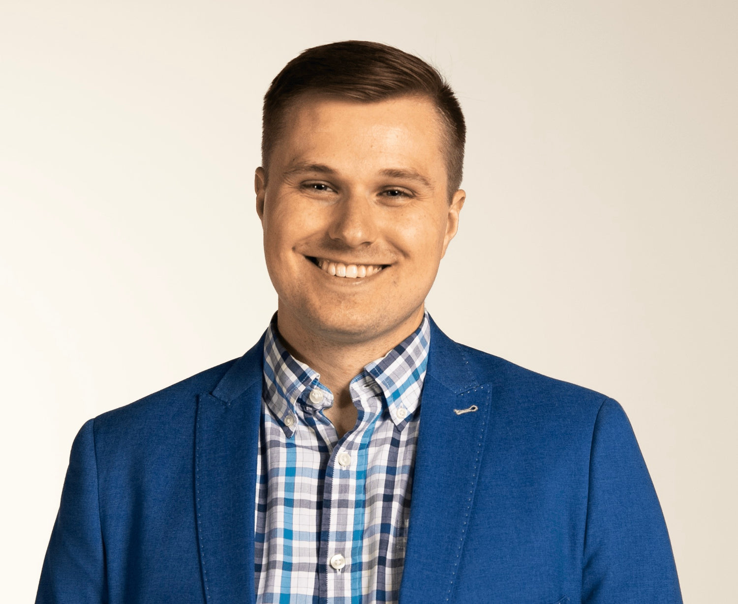 Hockey Hardware creator and FACE-OFF GAMES owner Billy Morrison smiling for a picture wearing a royal blue jacket over a white and blue plaid dress shirt.
