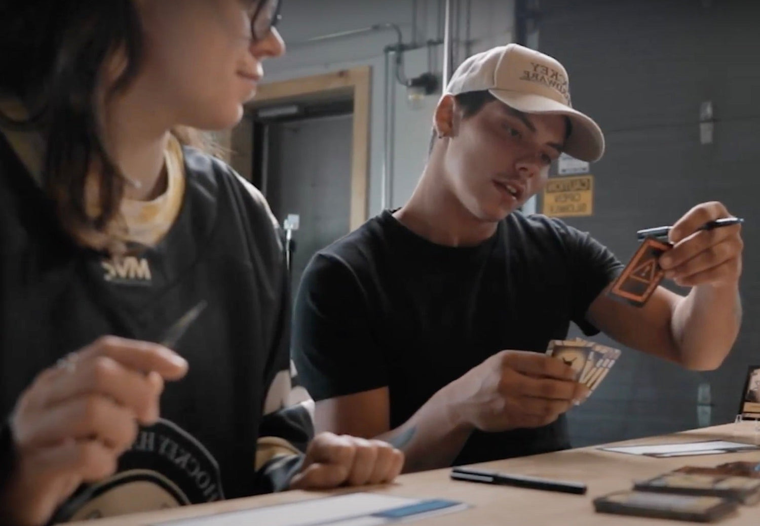 A young adult man draws an Adversity Card while playing Hockey Hardware.